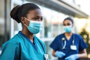 nurse standing outside of a hospital building